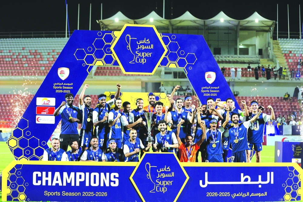 Al Shabab players celebrate on the podium after winning the Super Cup title against Seeb