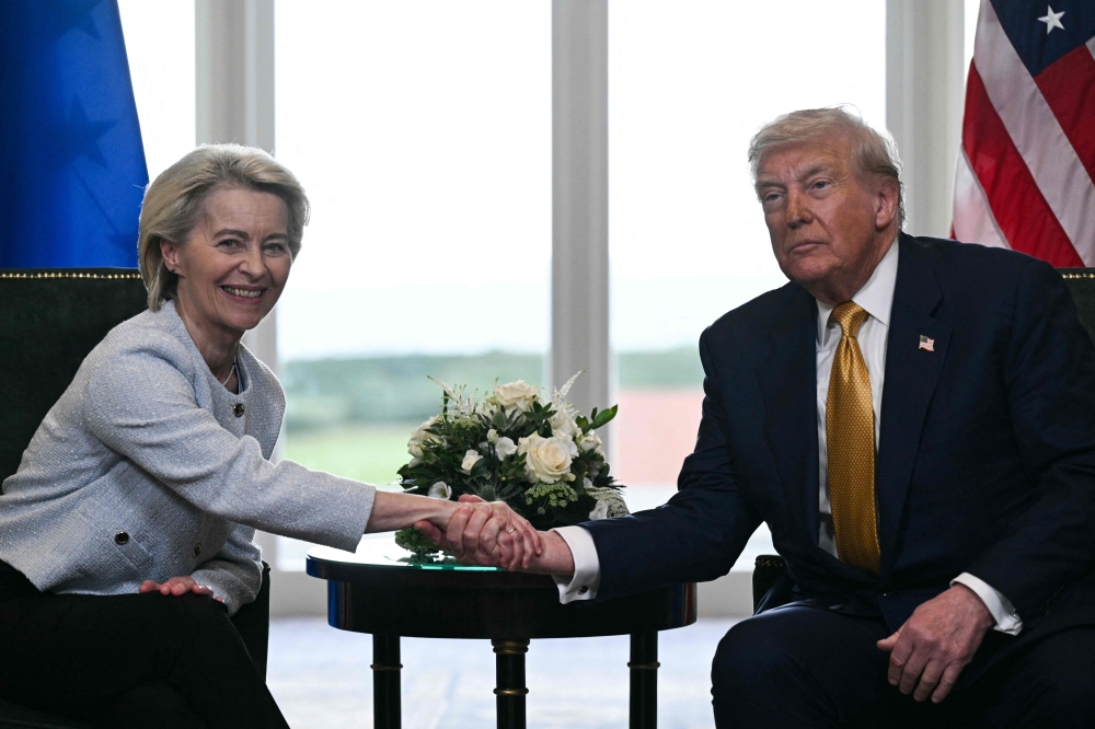 US President Donald Trump (R) shakes hands with European Commission President Ursula von der Leyen (L