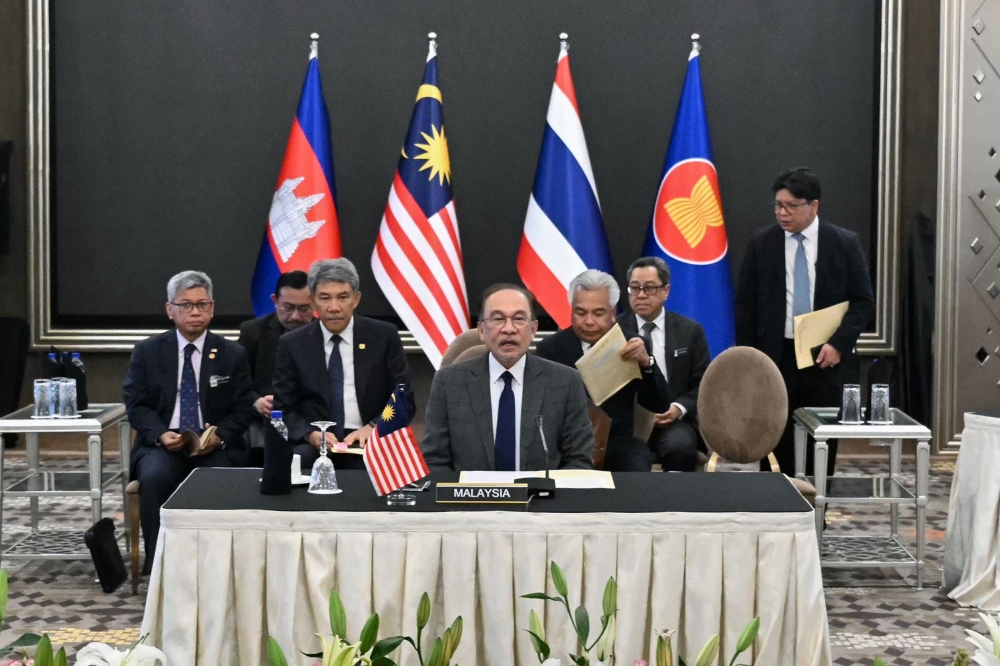 Malaysia's Prime Minister Anwar Ibrahim (C) mediates talks with Cambodia's Prime Minister Hun Manet and Thailand's acting Prime Minister Phumtham Wechayachai on a possible ceasefire between Thailand and Cambodia in Putrajaya on July 28