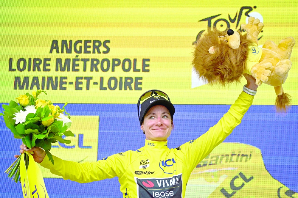 Team Visma | Lease a Bike's Dutch rider Marianne Vos celebrates on the podium with the overall leader's yellow jersey after the 3rd stage. — AFP