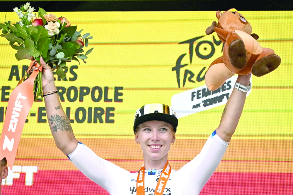 Dutch rider Lorena Wiebes celebrates on the podium after winning the 3rd stage. — AFP