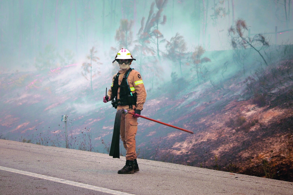 A firefighter monitors a wildfire in Pombal, Portugal. — AFP