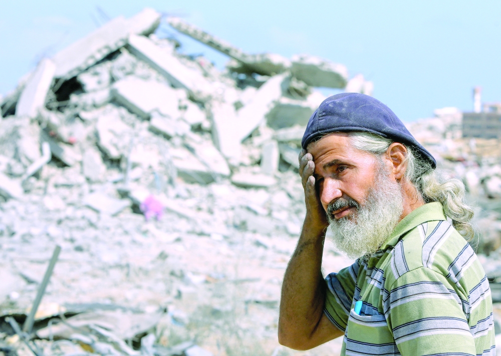 
A Palestinian man reacts at the site of houses destroyed during an Israeli raid, in western part of Nuseirat, central Gaza Strip, on Tuesday. — Reuters 