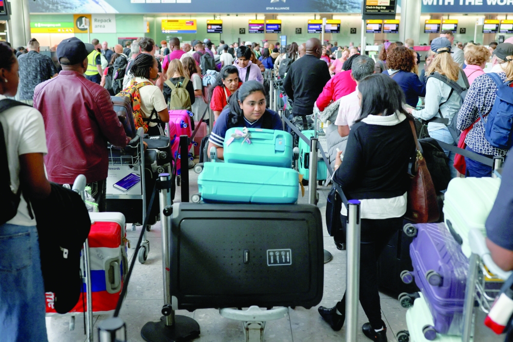 Passengers wait in line at Heathrow Airport, after radar failure led to the suspension of outbound flights across the UK, in Hounslow, London. — Reuters
