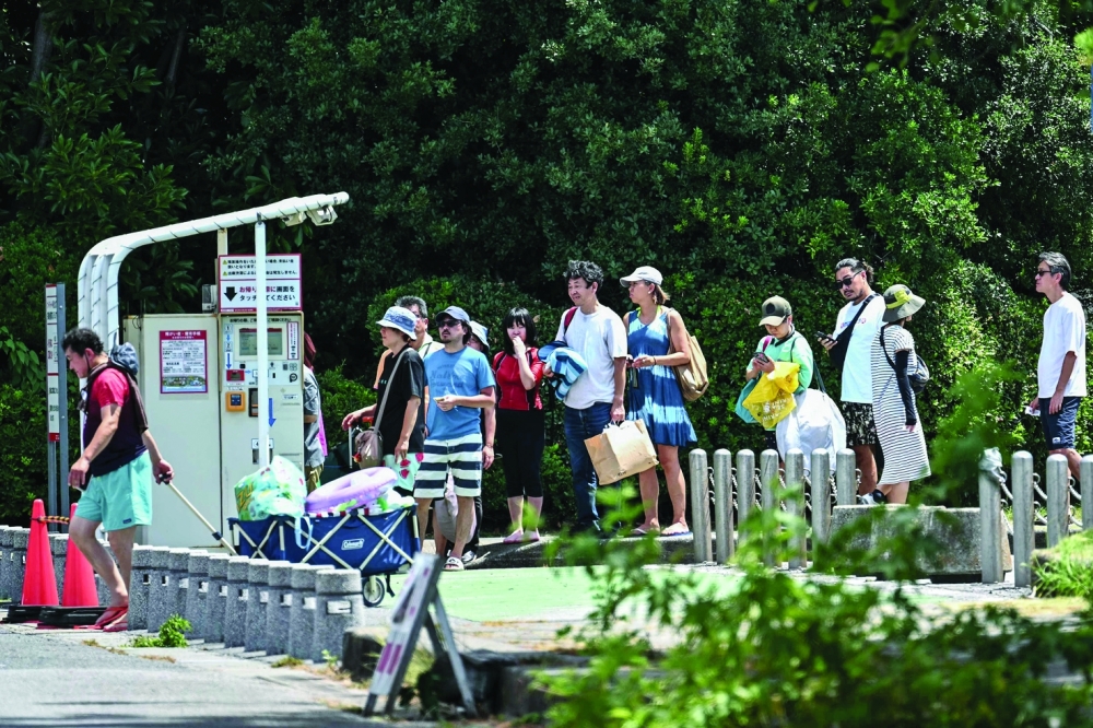 People leave the beachside area at Inage Seaside Park after much of coastal Japan went on tsunami alert following an 8.8-magnitude quake in the sea off eastern Russia, along Tokyo Bay in Chiba City, Chiba prefecture. - AFP
