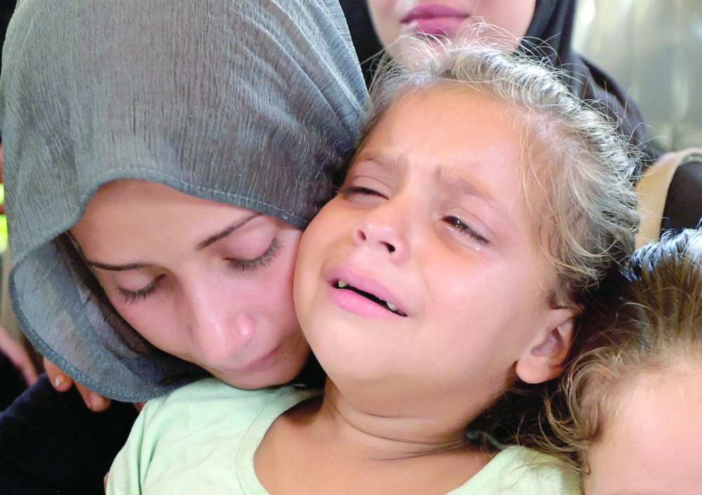
A woman and a child react during the funeral of Palestinians in Khan Yunis on Thursday. — Reuters 