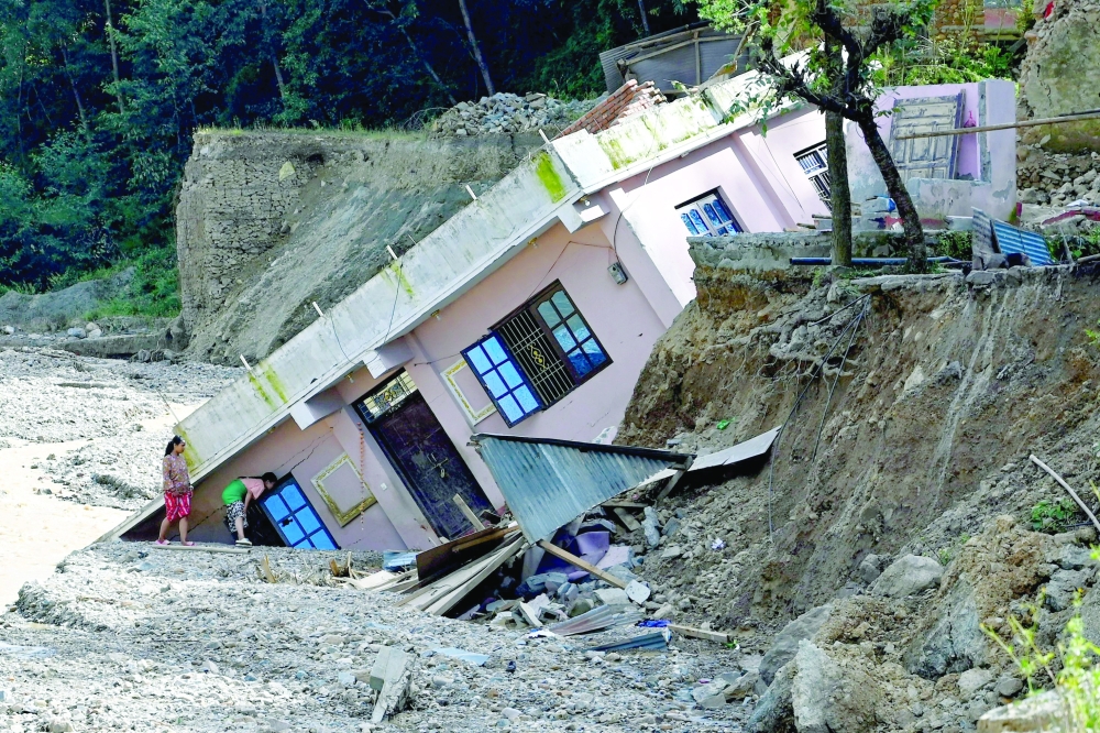 A damaged building, uprooted following heavy rains at a landslide-affected village in Lalitpur district on the outskirts of Kathmandu. — AFP