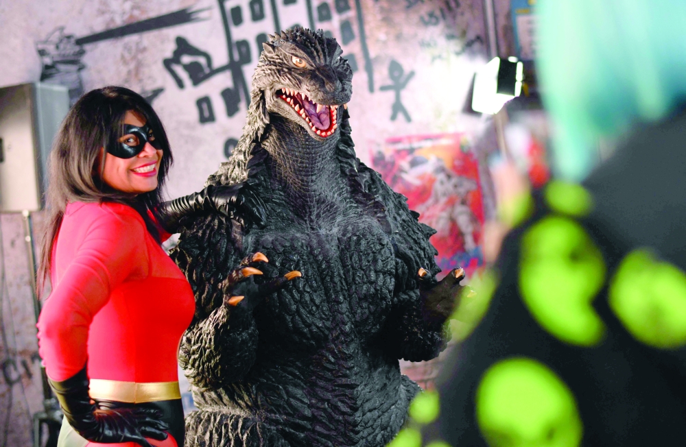 An attendee poses for photos with Godzilla during Comic-Con International in San Diego, California, on July 26, 2025. (Photo by Chris DELMAS / AFP)
