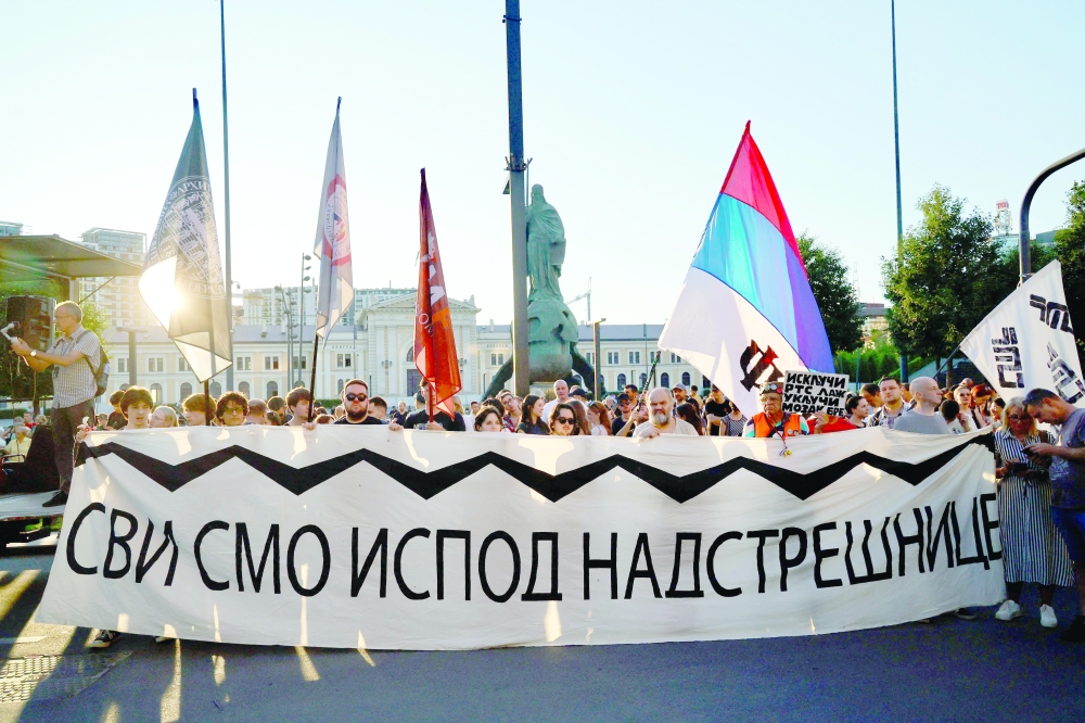 Protesters gather holding a banner, in Belgrade. — AFP