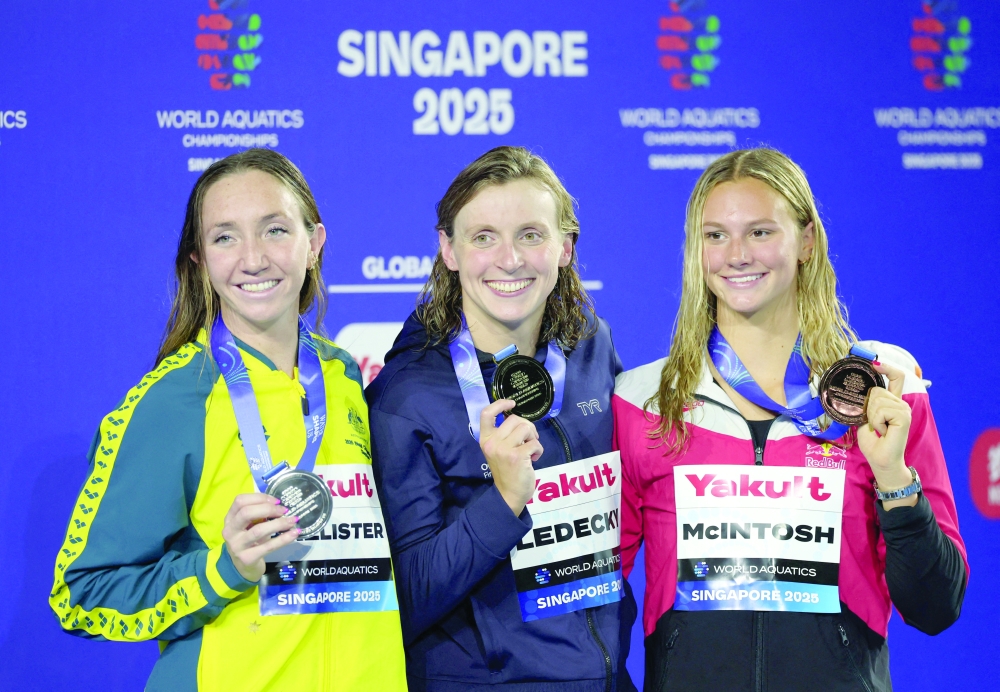 Gold medallist Katie Ledecky of the US celebrates with her medal after winning the Women's 800m Freestyle Final alongside silver medallist Australia's Lani Pallister and bronze medallist Canada's Summer McIntosh. — Reuters