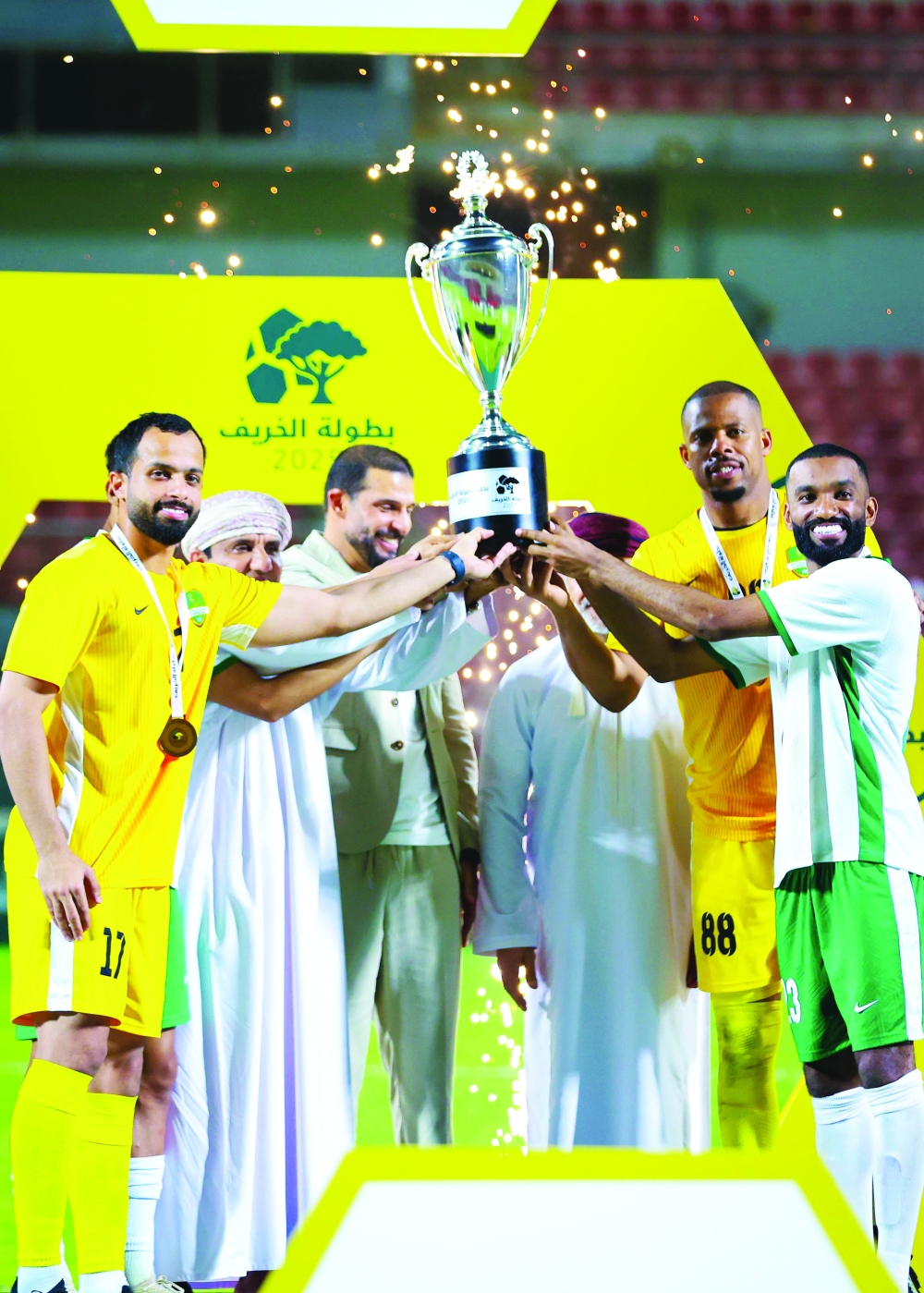 Al Nahda's players receive the trophy.