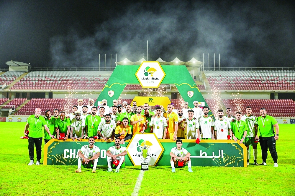 Al Nahda's players celebrate with the trophy.