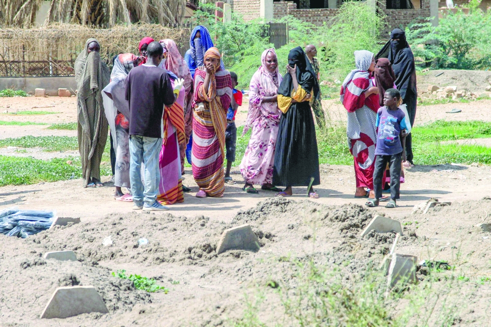 People gather by the makeshift graves