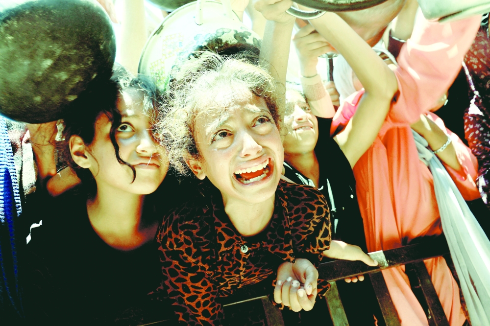 Palestinians wait to receive food from a charity kitchen, amid a hunger crisis, in Khan Yunis, southern Gaza Strip, on Monday. - Reuters