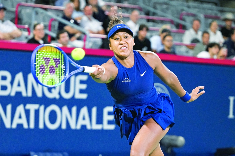 Naomi Osaka (JPN) returns the ball to Clara Tauson (DEN) in semifinal play at IGA Stadium. — Imagn Images