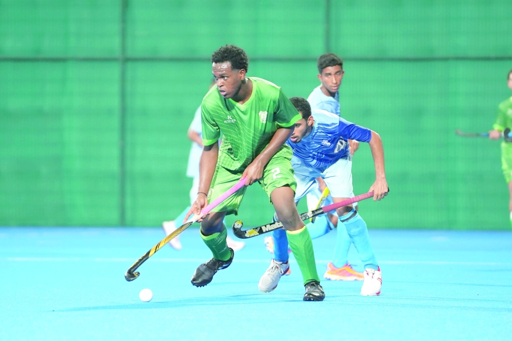 Al Ittihad and Masirah players fight for the ball.