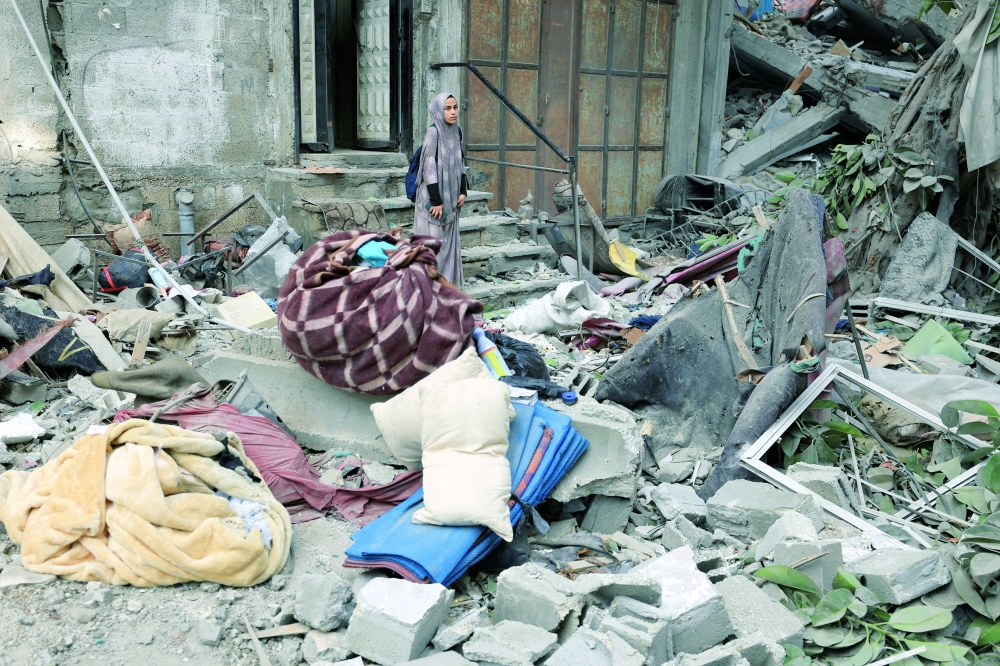 
A Palestinian woman inspects the site of an overnight Israeli strike on a house in Gaza City on Thursday. — Reuters 