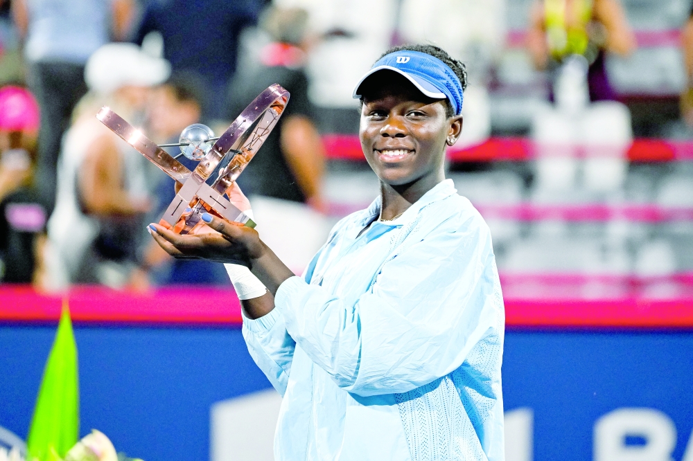 Victoria Mboko (CAN) tournament winner against Naomi Osaka (JPN) holds her trophy at IGA Stadium. -- Imagn Images