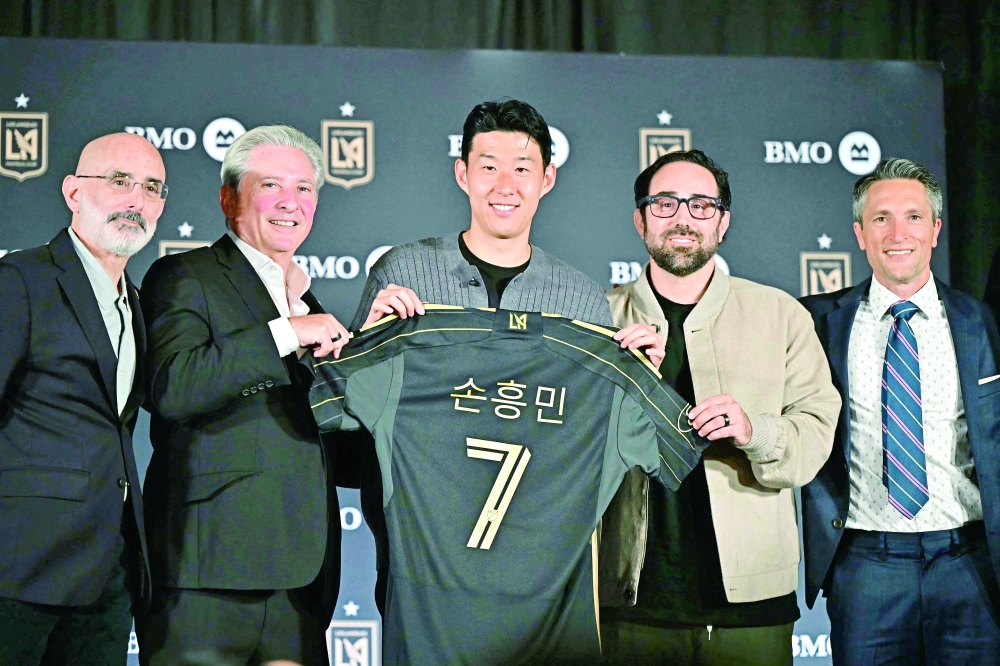 South Korean football player Son Heung-min (C) holds his LAFC jersey alongside LAFC Lead Managing Owner Bennett Rosenthal (2nd L), LAFC Co-Managing Owner Brandon Beck (2nd R) and LAFC Co-President and General Manager John Thorrington (R) during a press conference as he joins the Los Angeles FC (LAFC) at BMO Stadium's Field Club in Los Angeles on August 6, 2025. South Korea star Son Heung-min has signed for Los Angeles FC, bringing to an end his 10-year stay at Tottenham, both clubs announced on August 6, 2025. The 33-year-old will reportedly cost a Major League Soccer record $26 million transfer fee, according to ESPN and The Athletic.
 (Photo by Frederic J. Brown / AFP)
