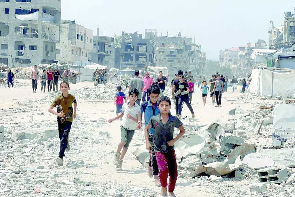 Palestinians run toward food parcels dropped by a military aircraft in Jabalia in the northern Gaza Strip on August 9, 2025. Gaza's civil defence agency said at least 10 people were killed across the Palestinian territory on August 9, including civilians who were waiting to collect aid. 