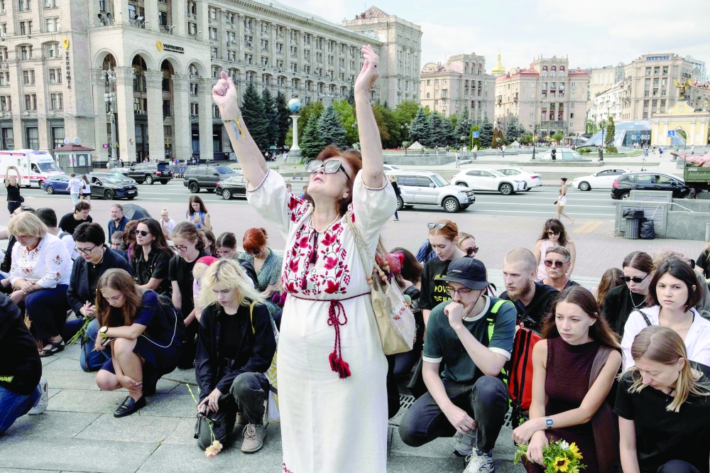 People kneel down during the funeral ceremony for Victoria Roshchyna, a Ukrainian journalist who died while in captivity in Russia, on Independence Square in Kyiv. — AFP
