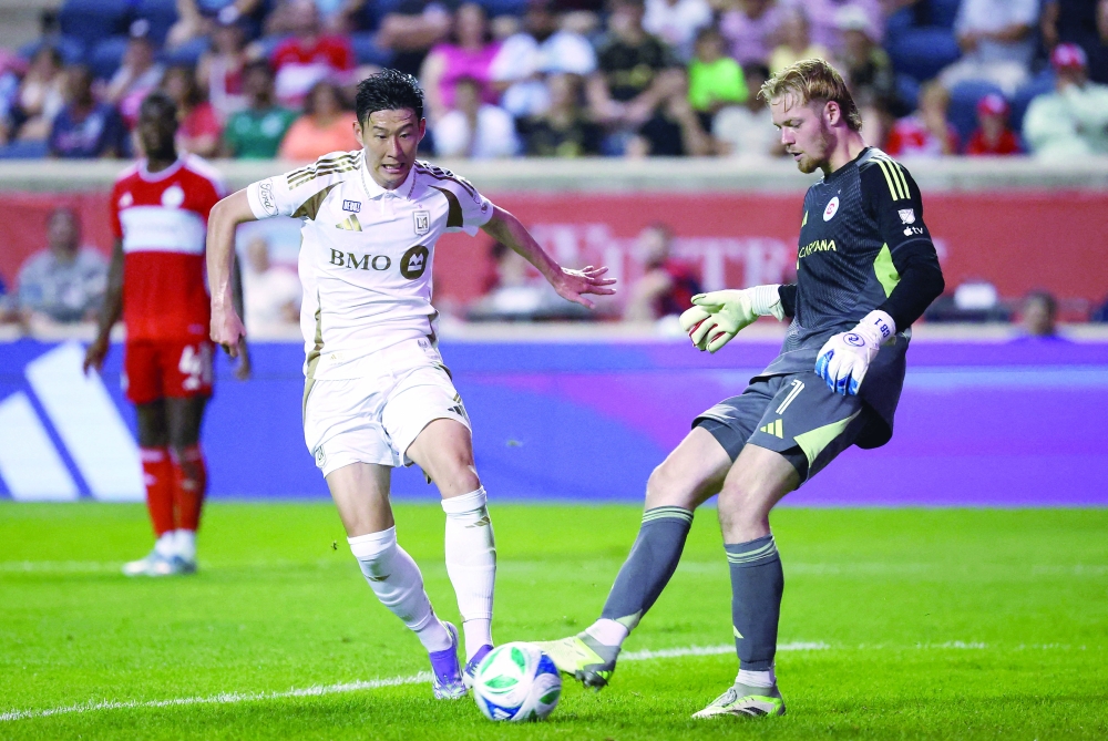 Son Heung-Min (7) and Chicago Fire goalkeeper (1) battle for control of the ball. — Reuters