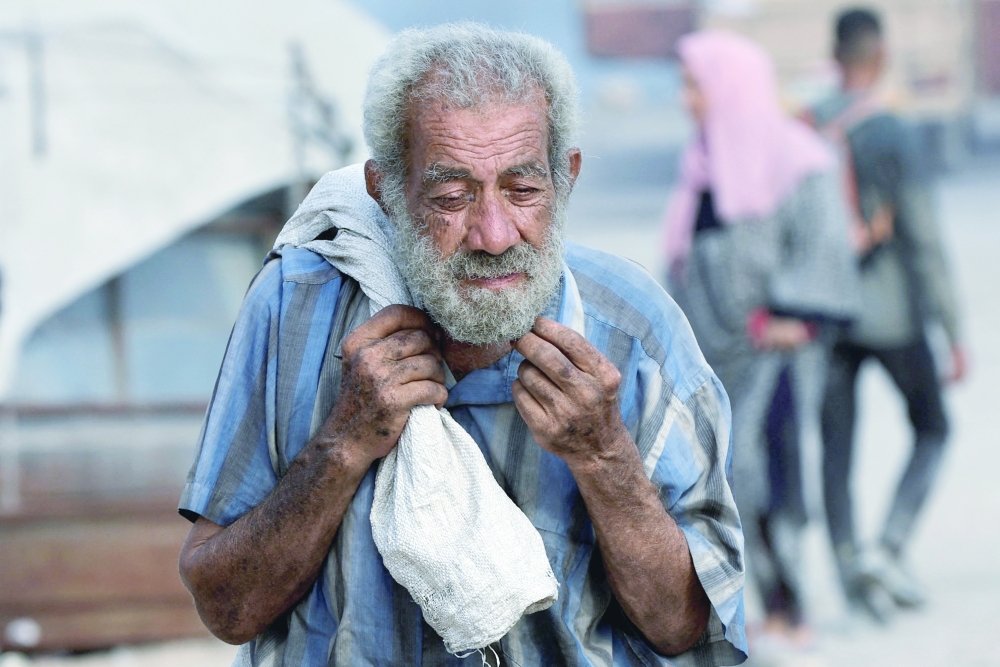 A Palestinian man carries aid supplies he collected from trucks that entered Gaza through Israel, in Beit Lahia, in the northern Gaza Strip, on Sunday. - Reuters