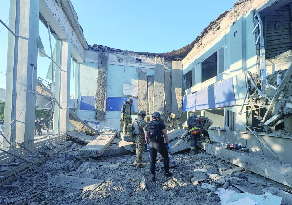 Rescuers and police officers work at the site of an air strike, in Zaporizhzhia, Ukraine. — Reuters