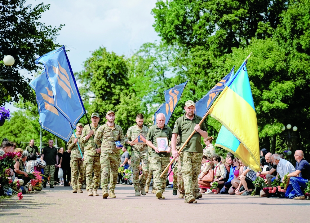 Ukrainian service members carry a coffin during a funeral ceremony in Chernihiv. — Reuters
