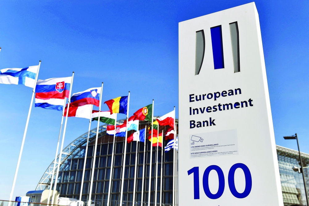 Flags are seen behind the logo of the European Investment Bank pictured in the city of Luxembourg, Luxembourg. — Reuters