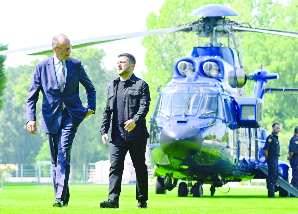 Ukrainian President Volodymyr Zelensky (R) and German Chancellor Friedrich Merz walk in the garden of the chancellery in Berlin. — AFP