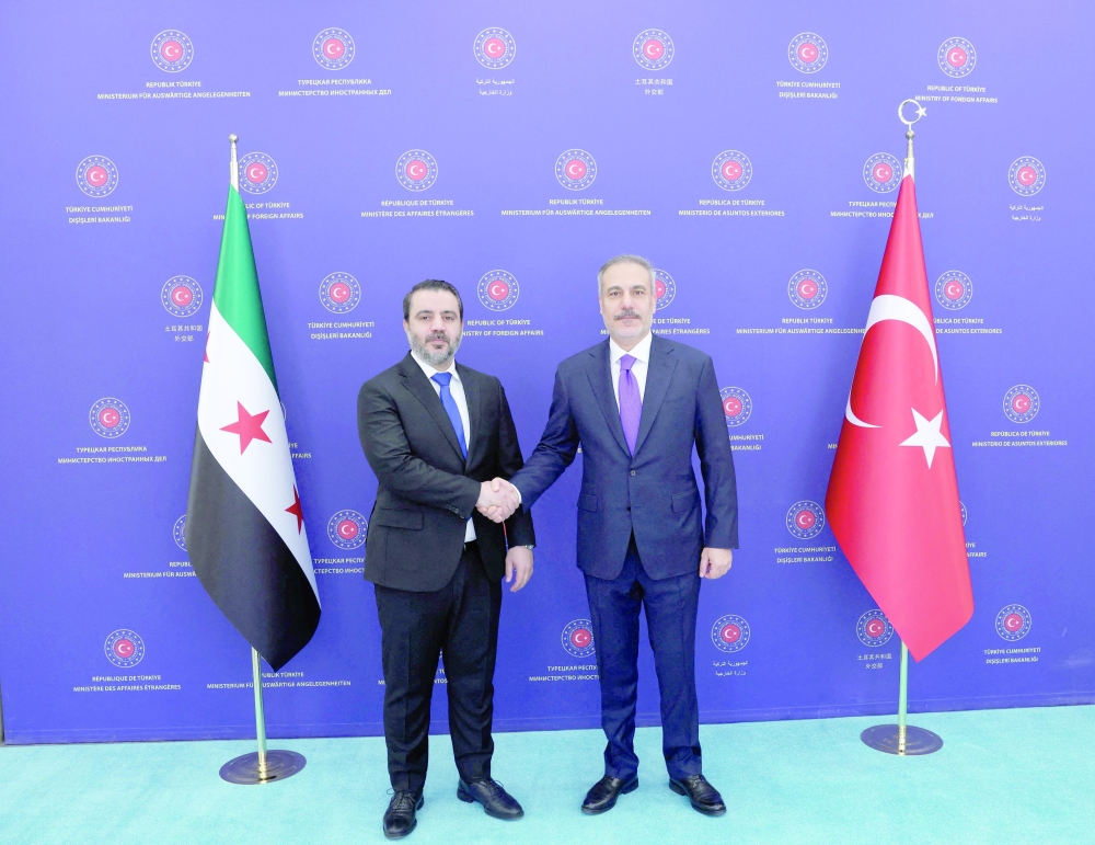 Turkish Foreign Minister Hakan Fidan shakes hands with his Syrian counterpart Asaad al Shaibani as they meet in Ankara. — Reuters