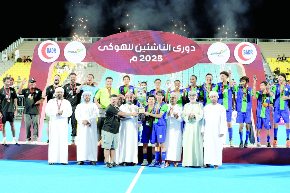 Ahli Sidab players celebrate with the league trophy.
