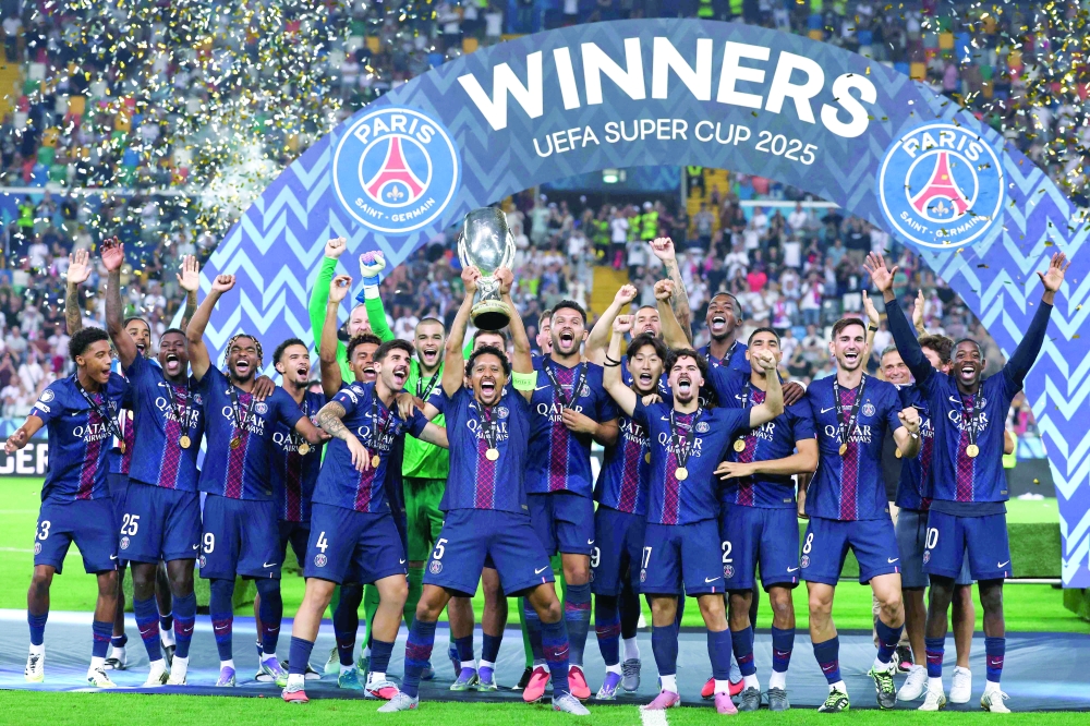 Paris Saint-Germain's Brazilian defender #05 Marquinhos (L) lifts the trophy as Paris Saint-Germain celebrate winning the 2025 Uefa Super Cup final football match between Paris Saint-Germain (FRA) and Tottenham Hotspur FC (ENG) at the Friuli stadium, in Udine, on August 13, 2025. (Photo by Marco BERTORELLO / AFP)