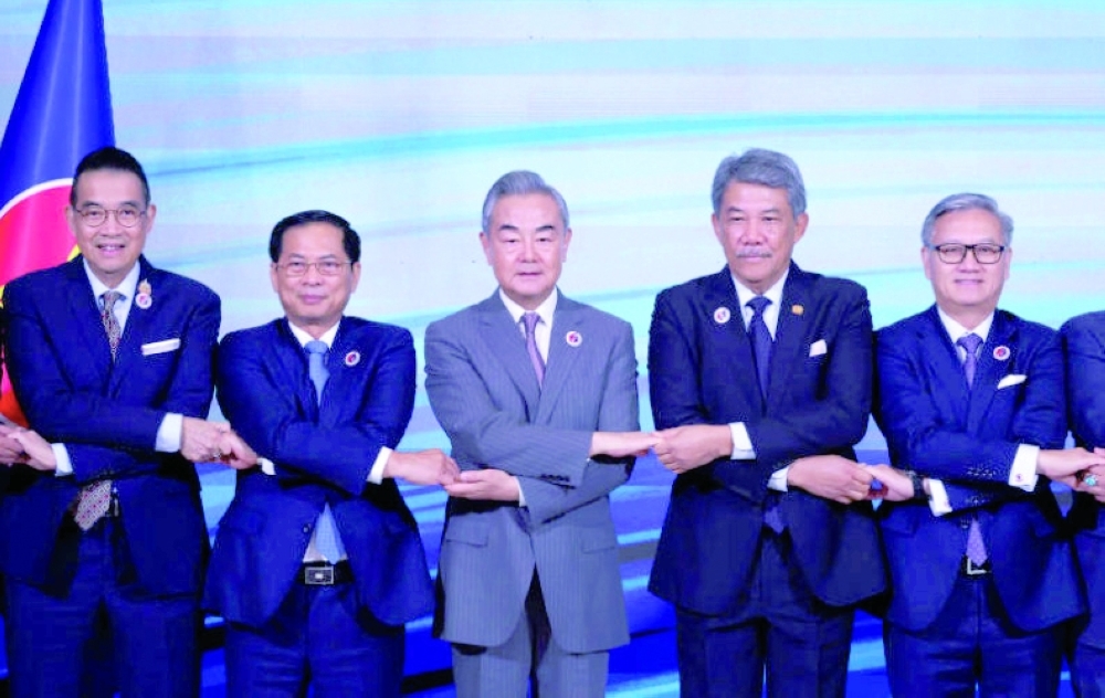 
Foreign Minister Maris Sangiampongsa (left) and Chinese Foreign Minister Wang Yi join hands with other Asean counterparts for a photo during the Asean Post-Ministerial Conference with China in Kuala Lumpur on Thursday. — Reuters File 