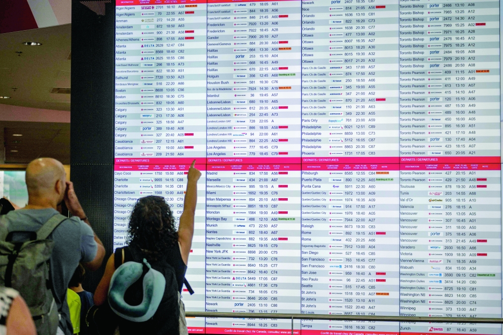 A flight board is seen at the Pierre-Elliott Trudeau Airport in Montreal. — AFP