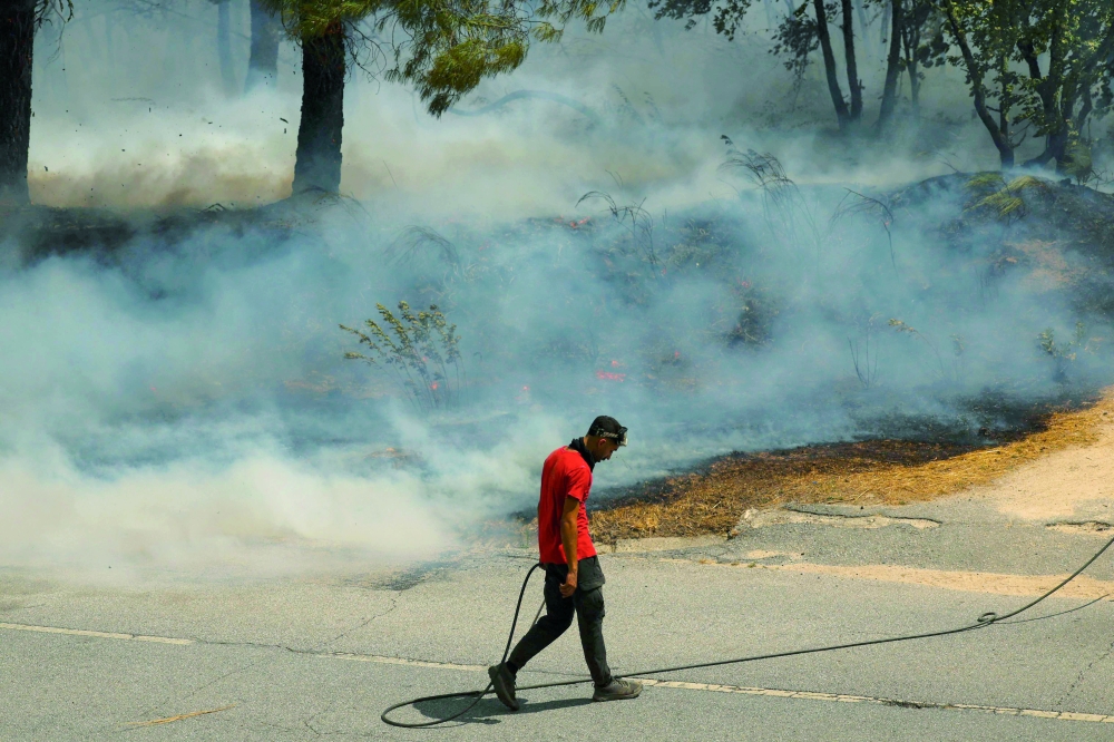 A man tries to extinguish a wildfire