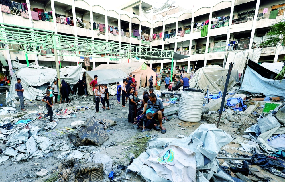 
Palestinians inspect the site of a Friday Israeli strike on a school that was sheltering displaced people, in Gaza City. — Reuters 