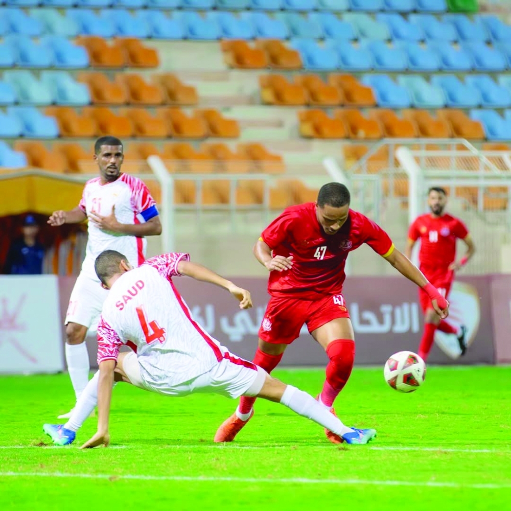 An Oman Club player tries to defend a Dhofar move.
