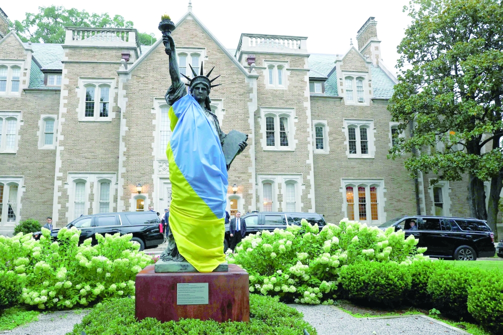 A scaled model of the Statue of Liberty draped in a Ukrainian flag stands in the French Embassy gardens in Washington, DC. — AFP