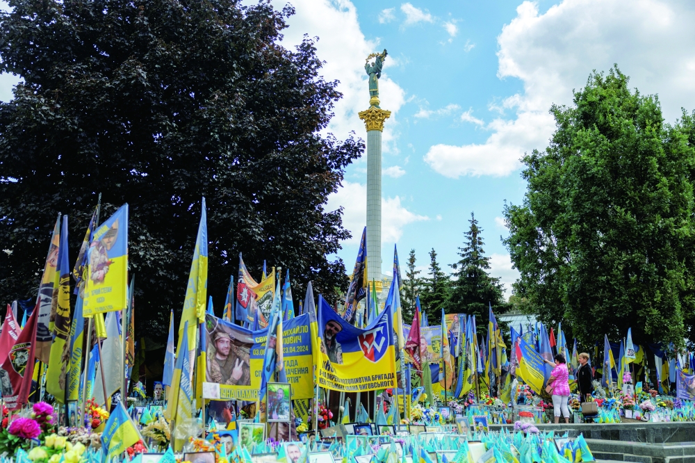 People visit a makeshift memorial to fallen Ukrainian defenders, at the Independence Square in Kyiv. — Reuters