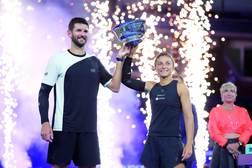 Italy's Andrea Vavassori (L) and Sara Errani celebrate with the trophy after winning their mixed doubles final match against Norway's Casper Ruud and Poland's Iga Swiatek at the US Open tennis tournament at the USTA Billie Jean King National Tennis Center in New York City, on Wednesday. — AFP