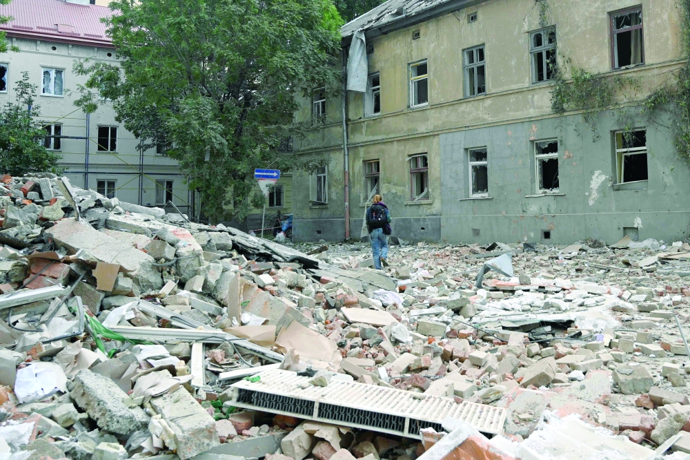 A person walks past a residential building damaged following Russian air attacks in the western Ukrainian city of Lviv amid the Russian war of Ukraine. - AFP