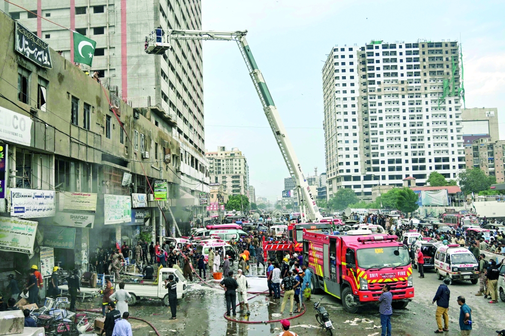 Firefighters work to douse a fire that broke out at a firecracker warehouse in Karachi on August 21, 2025.  
