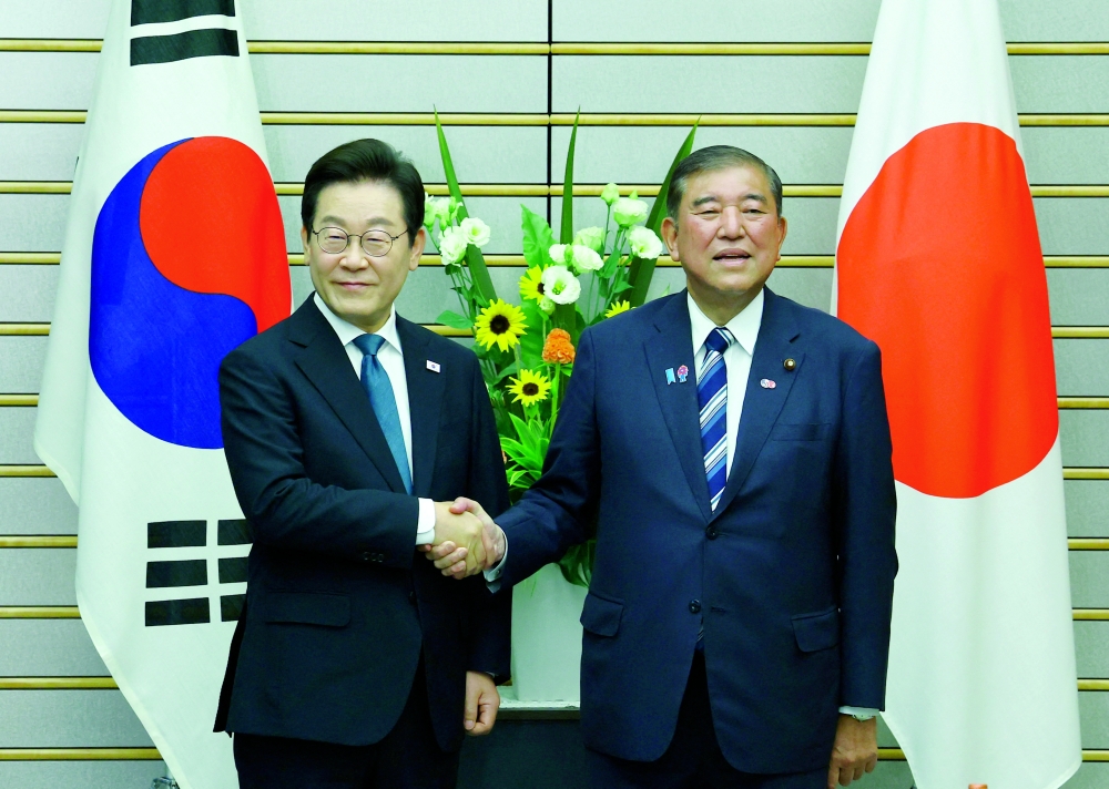 S Korea's President Lee Jae Myung shakes hands with Japan's PM Shigeru Ishiba, in Tokyo. — Reuters