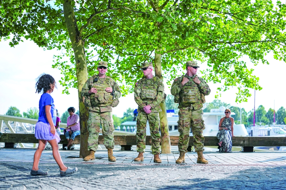 A child walks past members of the National Guard, in Washington. — AFP