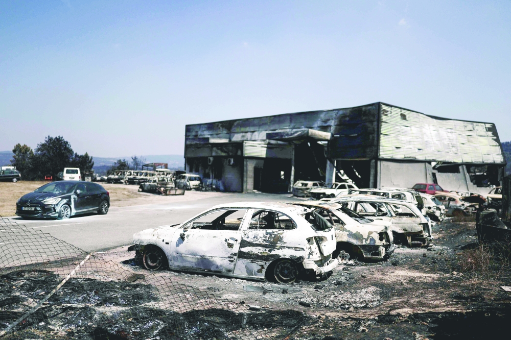 Burnt cars are pictured, in Sarzeda village in Trancoso, Portugal. — AFP