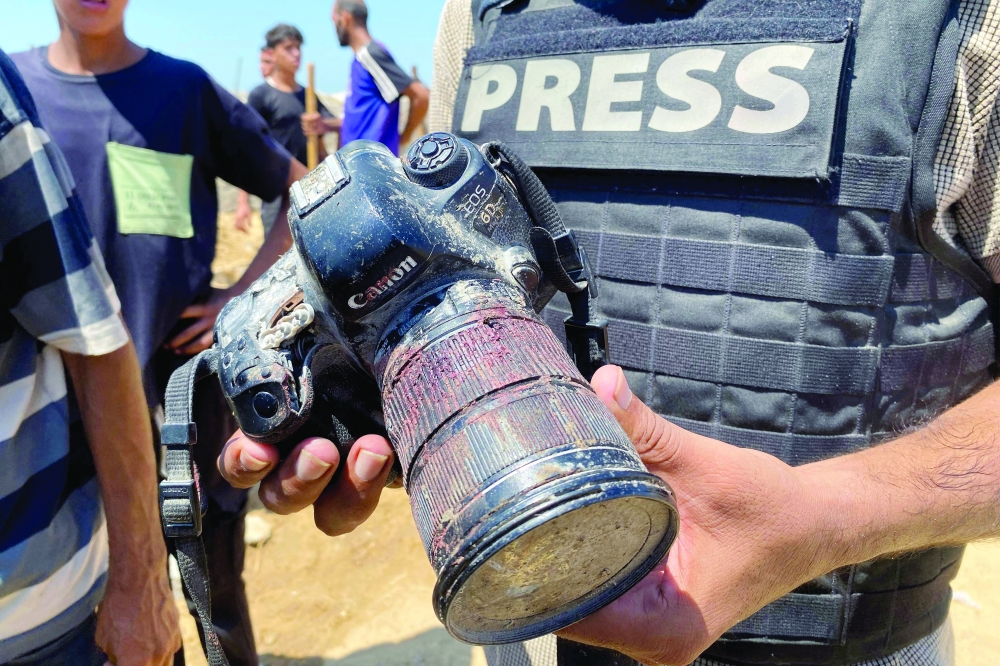 A journalist holds the blood-covered camera belonging to Palestinian photojournalist Mariam Dagga, a journalist who freelanced for AP and who was killed in an Israeli strike on Nasser hospital in Khan Yunis in the southern Gaza Strip on Monday. — AFP