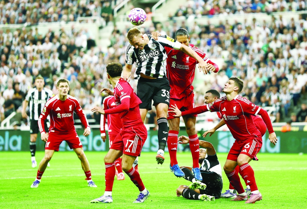 Newcastle United's Dan Burn in action with Liverpool's Virgil van Dijk. — Reuters