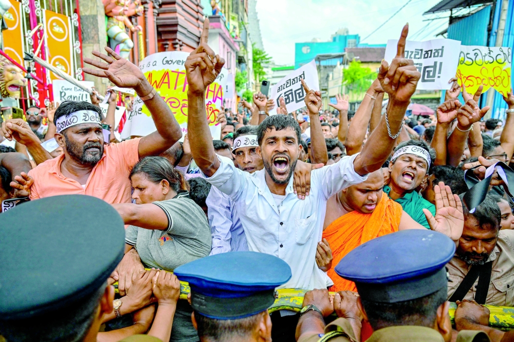 Supporters of former president Ranil Wickremesinghe shout slogans during a protest, in Colombo. — AFP